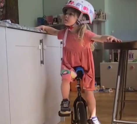 Daisy on the unicycle in the kitchen