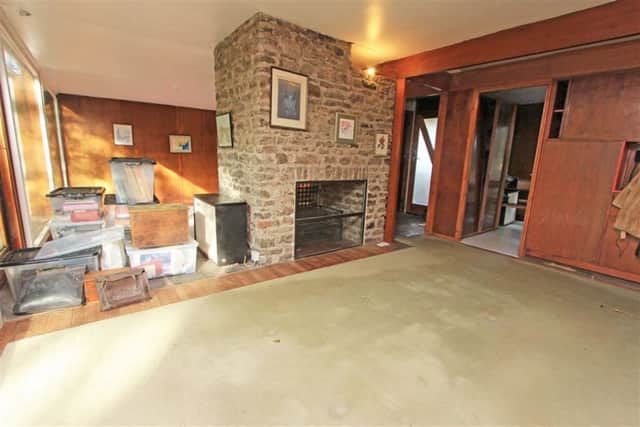 The split-level living room and dining room that are separated by a central stone-built fireplace.