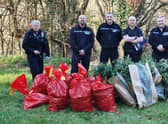 Police officers pose behind bags of cannabis discovered in Cadbury Camp Lane near Bristol