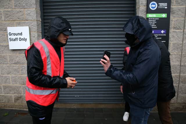 A Brighton & Hove Albion shows his COVID-19 passport to a steward. (Photo by Steve Bardens/Getty Images)