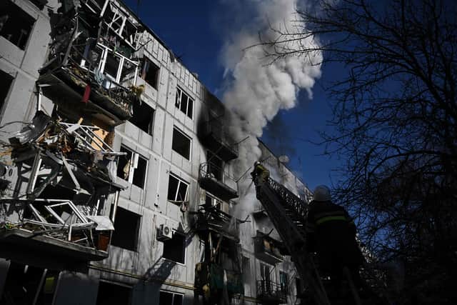 Firefighters work on a fire on a building after bombings on the eastern Ukraine town of Chuguiv on February 24, 2022, as Russian armed forces are trying to invade Ukraine from several directions, using rocket systems and helicopters to attack Ukrainian position in the south, the border guard service said.