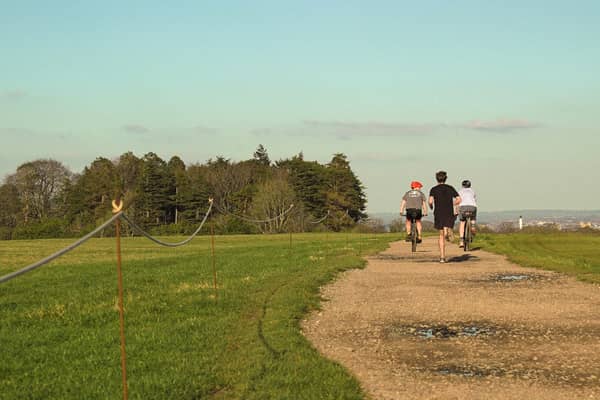 Cyclists and a runner enjoy the warm weather at the Ashton Court Estate in Bristol.