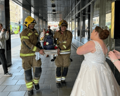 A bride who was due to tie the knot at the venue that afternoon but was evacuated along with everyone else in the building. Here she is being reunited with her wedding cake by firefighters.