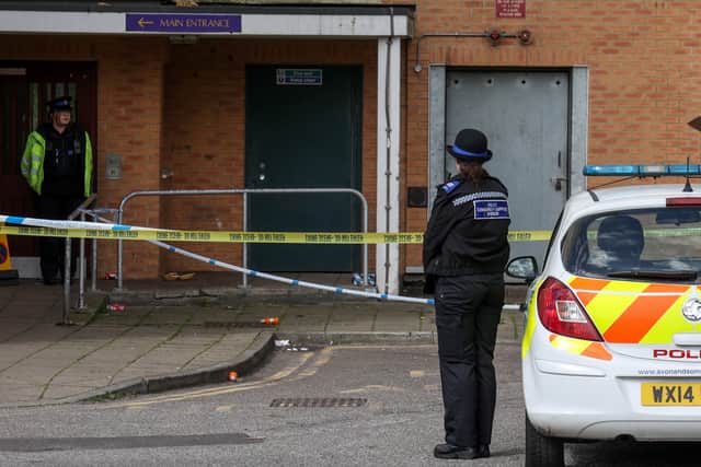 The block of flats is sealed off while the murder investigation continues.