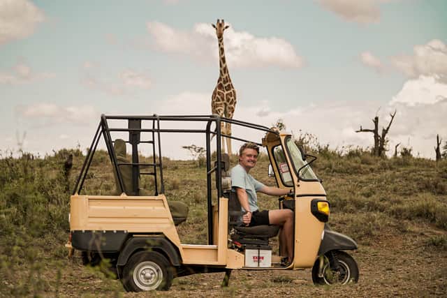 Josh and a giraffe in Ol Jogi, Kenya.