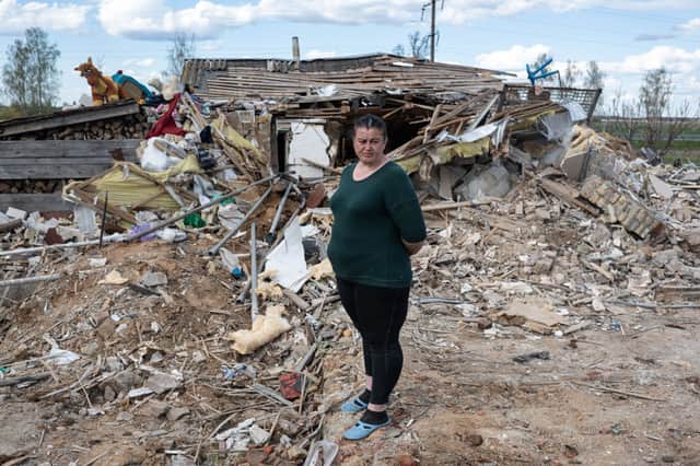 ZIryna Minenko, 35, stands in front of her destroyed house, on April 28 in Zahaltsi, Ukraine. 