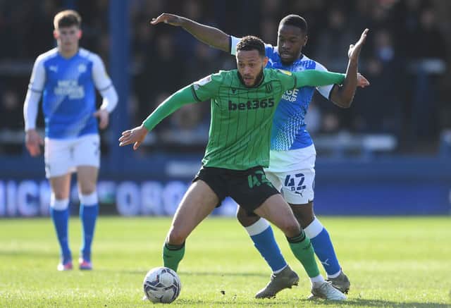 Lewis Baker of Stoke City is challenged by Jeando Fuchs of Peterborough United.