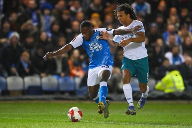 Jeando Fuchs of Peterborough United is challenged by Nathan Ake of Manchester City