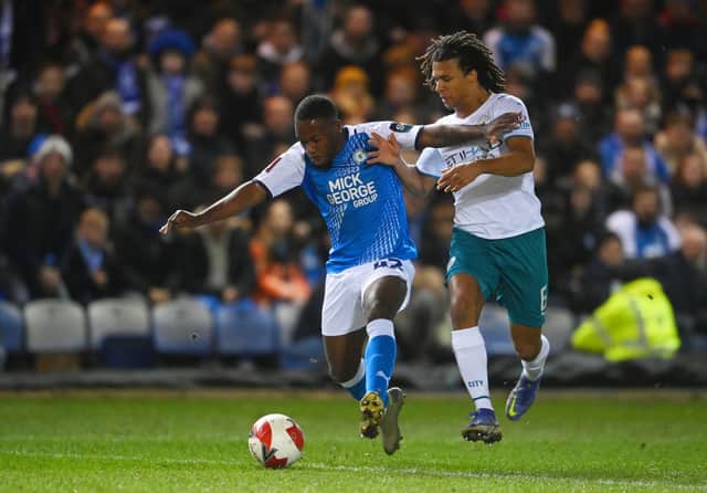 Jeando Fuchs of Peterborough United is challenged by Nathan Ake of Manchester City