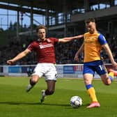 Rhys Oates of Mansfield Town is tackled by Fraser Horsfall of Northampton Town.