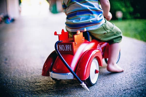 Stock image of a child riding a toy scooter.