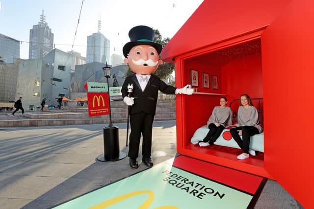 McDonalds super-fans Laura Paton and Emma Kendrick pose with Mr. Monopoly as they relax in McDonalds Monopoly Hotel, Australia.