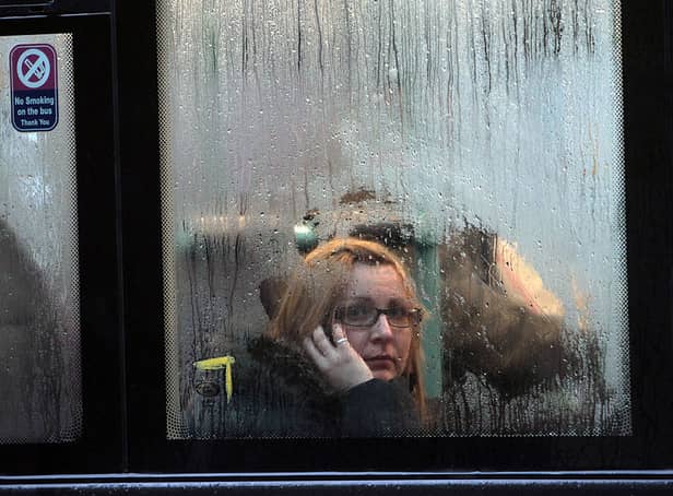 <p>A woman looks out of the window of a bus as it waits at a bus stop in the rain in Bristol (Photo by Matt Cardy/Getty Images).</p>