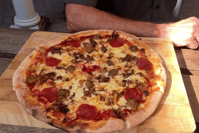 The pizza comes loaded with pulled pork, meatballs, pepperoni and BBQ sauce.