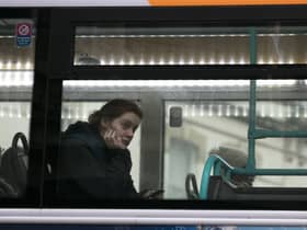 A woman looks out of the window of a First Bus in central Bristol.