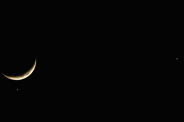 The planet Venus appears close to the crescent Moon as Jupiter (R) appears nearby during a rare planetary alignment in 2008.