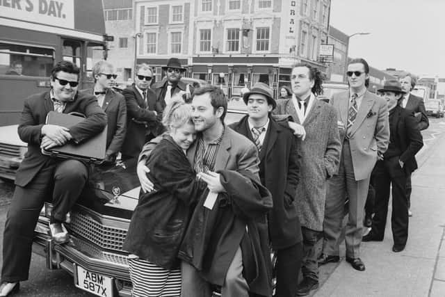 Film producer Alison Owen and her husband actor Keith Allen with cast members actors Robbie Coltrane, Adrian Edmondson, Peter Richardson, Kevin Allen and Clive Russell posing around Cadillac on the set of ‘The Supergrass’ outside Pentonville Prison on Caledonian Road in London in 1985. 