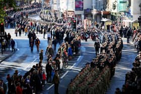 Locals line the street as members of the armed forces and veterans march during a Remembrance Day in Bristol.