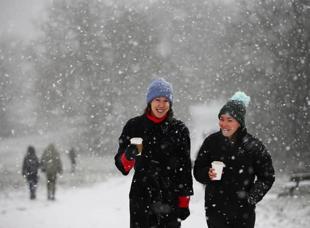 <p>Two women walk as snow falls. (Photo by Hollie Adams/Getty Images)</p>