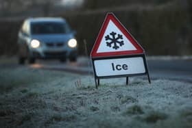 A warning triangle alerts drivers to an icy road.