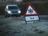 A warning triangle alerts drivers to an icy road.