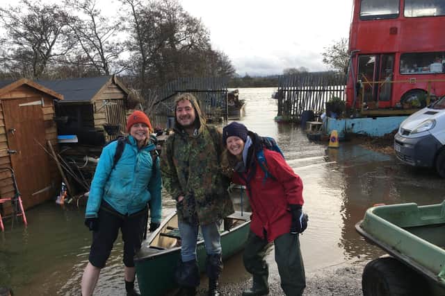 Jo Taylor (left) with residents on Phoenix Marine before heading out on a canoe through the hole in the gate behind them