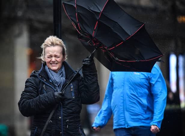 <p>A woman battles to keep control of her umbrella as she walks through a rain shower in Glasgow.</p>
