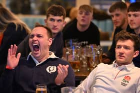 A Scotland fan celebrates while surrounded by England fans during the Scotland v England at the Bambalan bar on February 5, 2022 in Bristol, England. 