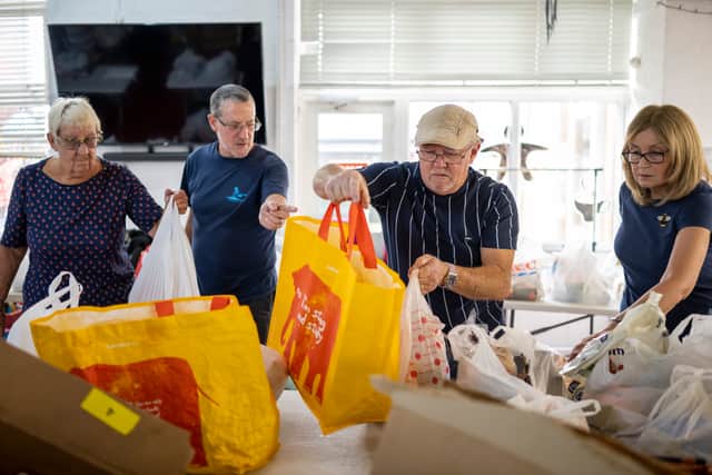 Volunteers sort food into food parcels at a community charity.  