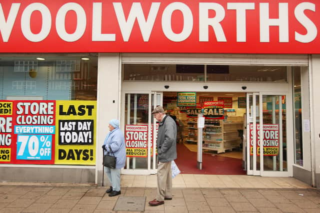 Shoppers pass a Woolworths shop on it’s last day of trading on December 27, 2008.