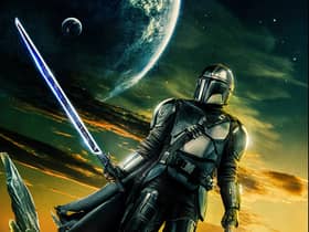 A promotional image for The Mandalorian S3, depicting Pedro Pascal as Din Djarin in front of a yellow and green sky (Credit: Disney+)