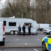 Police talk to the people inside the caravans on Bath East Hill car park in Keynsham