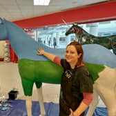 Kim Reed with the life-size unicorn she is painting in the former TK Maxx in the Galleries