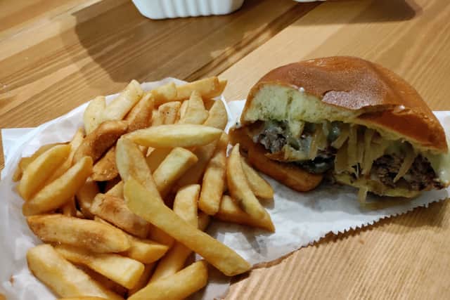 Inside the delicious Italian burger with the chips next to it from Dream Burger in Brislington