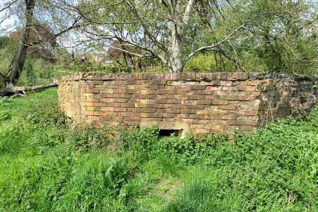 The well preserved pillbox with the village of Freshford in the background over the River Frome