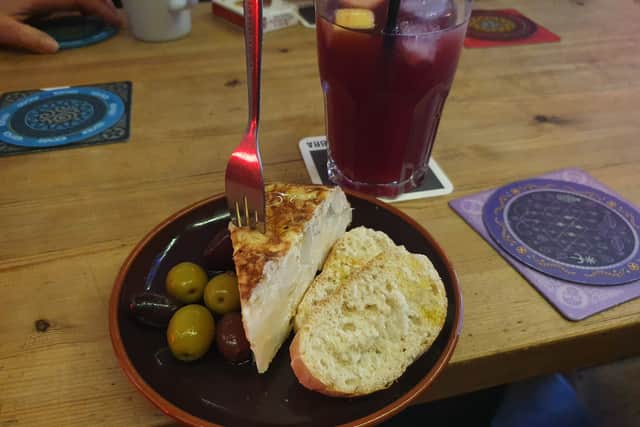 Tortilla tapas which was accompanied by some olives and two slices of bread and topped with a drizzle of oil