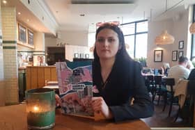 A member of Animal Rising protests at a table at the Cow & Sow in Queens Square