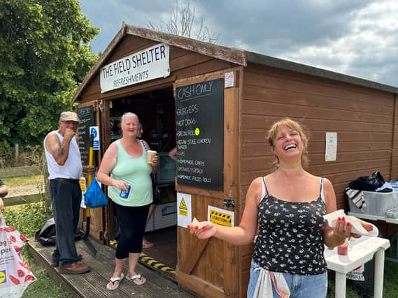 Nikki Lewis runs the food stall. It started as a gazebo, but not its a wooden hut and today she’s busy selling everything from coffee to hot dogs to hunger buyers and sellers. 