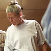 Corrections officer Sandra Fuentes (L) assists inmate Leslie Van Houten (R) as arrives for her parole hearing before members of the Board of Prison Terms 28 June 2002 at the California Institution for Women in Corona, California.