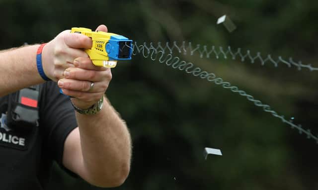 File photo 26/02/13 of a police officer demonstrating the use of a Taser as a majority of the public think it is acceptable for police to carry Tasers when on patrol, a survey suggests.